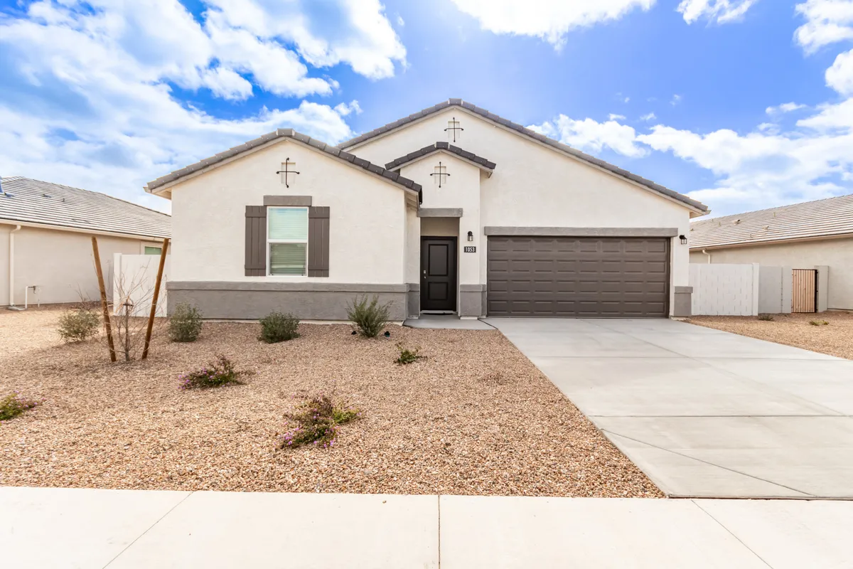 An exterior view of the home's front entrance, including the garage door and well-kept landscaping. The image provides a sense of privacy and secure access, highlighting the two-car garage and the welcoming arrival experience.